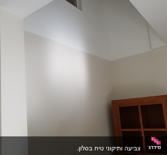 סולם צהוב ליד קיר צבוע בלבן